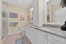 Bathroom featuring double vanity, a shower stall, recessed lighting, and light tile patterned flooring