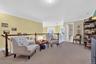 Living area with ornamental molding, light colored carpet, and an upstairs landing
