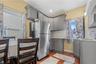 Kitchen featuring gray cabinets, freestanding refrigerator, ventilation hood, light wood-style flooring, and tasteful backsplash