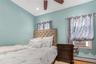 Bedroom with a baseboard radiator, cooling unit, wood finished floors, ceiling fan, and recessed lighting