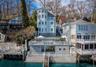 The property features a distinctive multi-story design with numerous windows, and multiple outdoor deck areas offering views of the water
