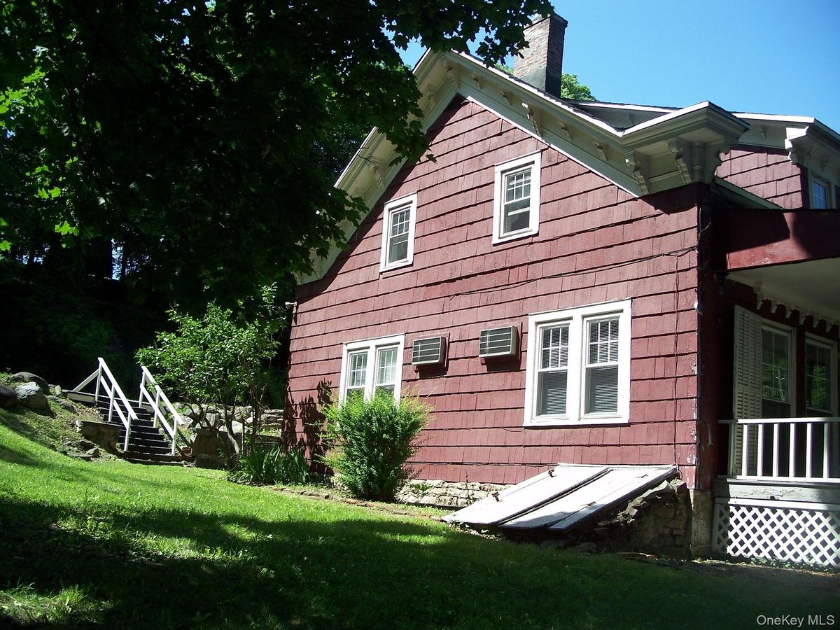 View of property exterior with a chimney and a lawn
