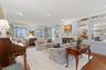 Living room with wood finished floors, ornamental molding,  fireplace, and recessed lighting