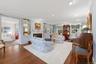 Living room featuring ornamental molding, dark wood-type flooring, a glass covered fireplace, and recessed lighting