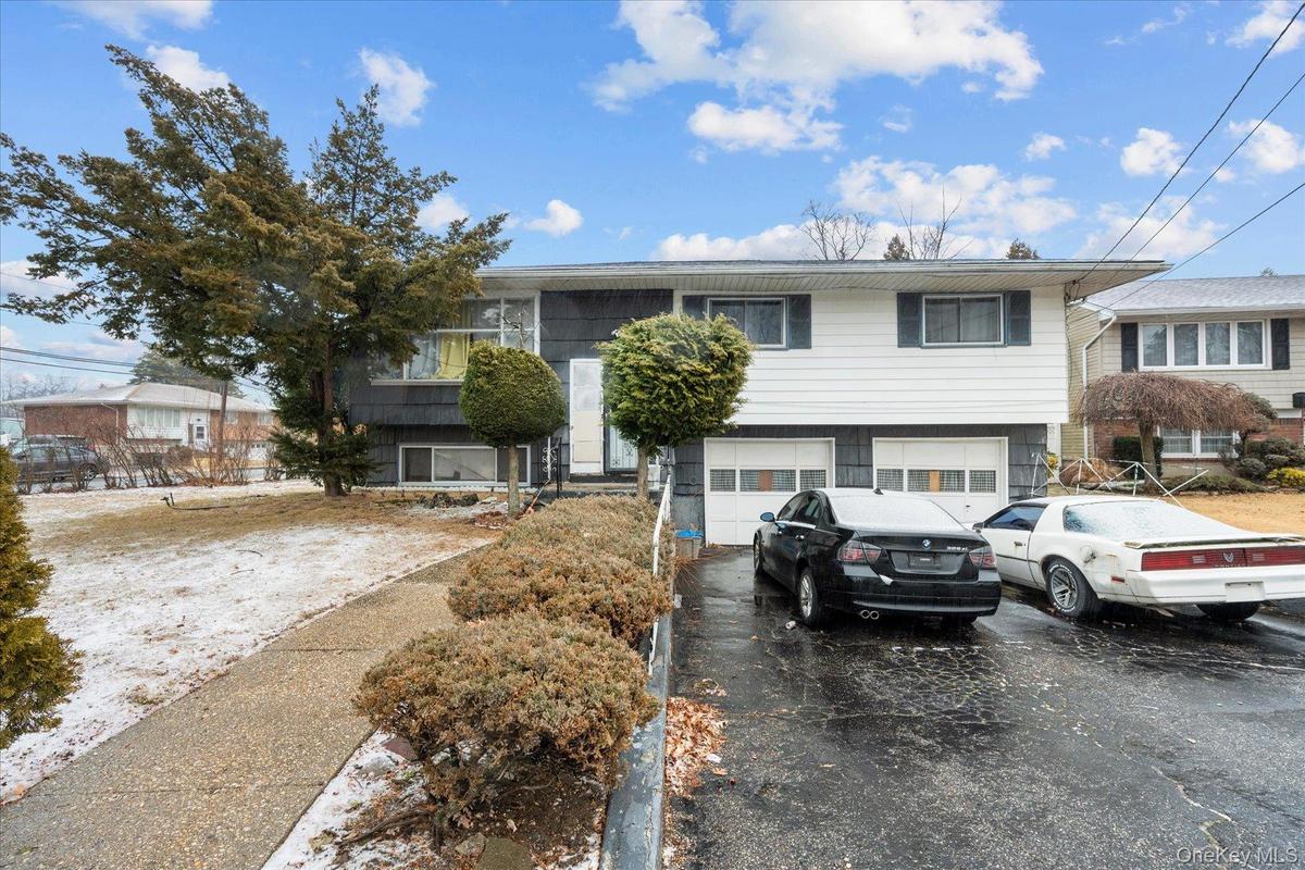 View of front of property with a garage and aphalt driveway