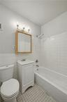 Full bath with vanity, tile walls, shower / bathtub combination, and light tile patterned floors