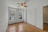 Unfurnished bedroom featuring a baseboard radiator, light wood-style flooring, a ceiling fan, and a closet
