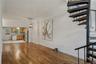 Unfurnished living room featuring stairs, light wood finished floors, ornamental molding, and a chandelier