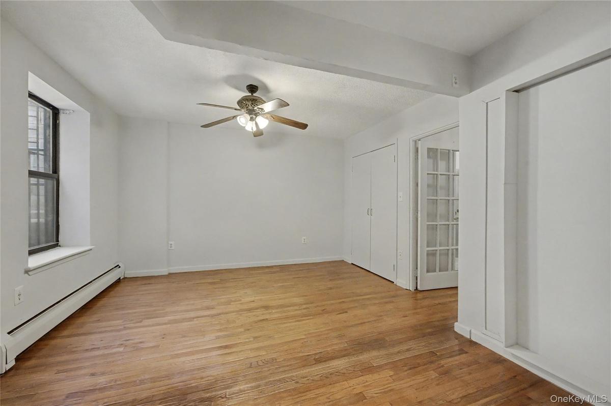Spare room featuring baseboard heating, light wood finished floors, and ceiling fan