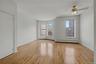 Spare room featuring light wood-type flooring, a baseboard radiator, and ceiling fan