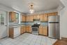 Kitchen featuring appliances with stainless steel finishes, light countertops, light brown cabinetry, and backsplash