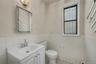 Half bath with vanity, tile walls, wainscoting, and tile patterned flooring