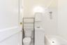 Full bath with tile walls, vanity, bathing tub / shower combination, and a wainscoted wall