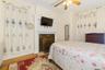 Bedroom with wood finished floors, a ceiling fan, and radiator heating unit