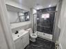 Second Floor Bathroom featuring tile walls, vanity, a tile finish shower, and dark tile finish floors
