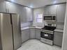 Second Floor Kitchen featuring stainless steel appliances, gray cabinetry, light tile finish flooring, and tasteful backsplash