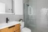 Bathroom featuring tile walls, vanity, a walk in shower, and tasteful backsplash