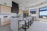 Kitchen with light brown cabinetry, modern cabinets, a breakfast bar, and hanging light fixtures