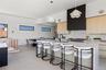 Kitchen featuring light brown cabinetry, modern cabinets, decorative backsplash, a breakfast bar, and hanging light fixtures