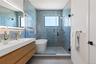 Full bath featuring a shower stall, tile walls, vanity, a soaking tub, and light tile patterned flooring