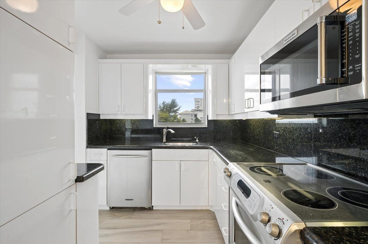 KITCHEN WITH STAINLESS STEEL APPLIANCES AND GRANITE COUNTER TOPS.
