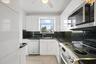 KITCHEN WITH STAINLESS STEEL APPLIANCES AND GRANITE COUNTER TOPS.