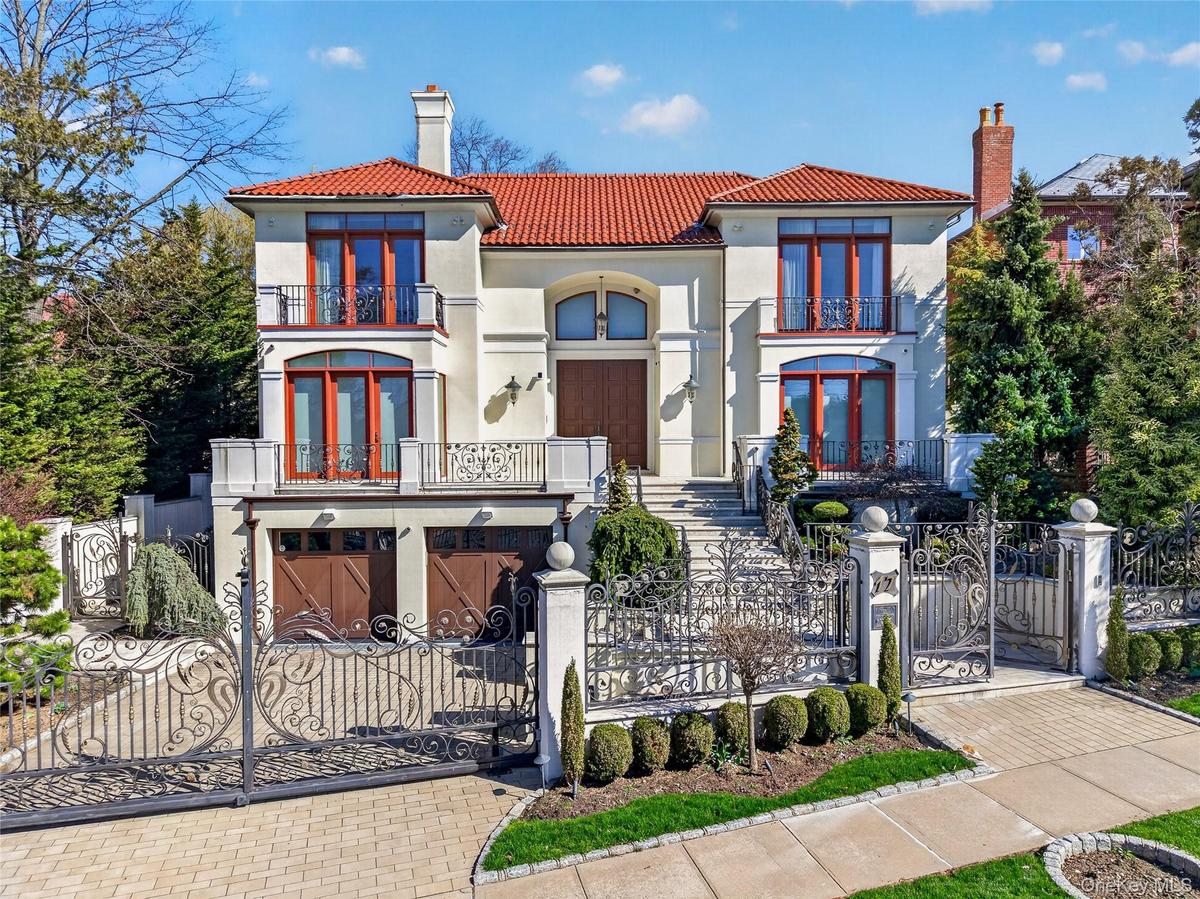 Mediterranean / spanish house with a chimney, a gate, a fenced front yard, a balcony, and stucco siding