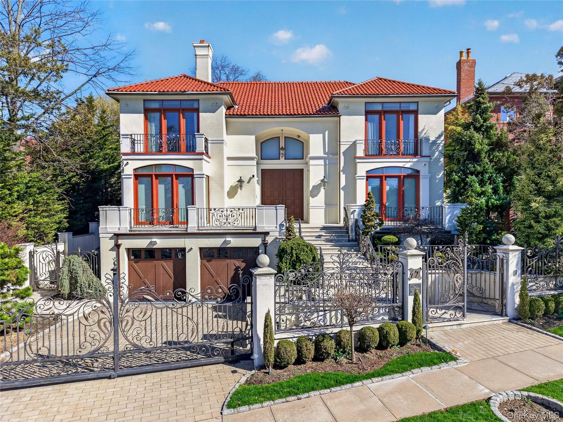 Mediterranean / spanish house with a chimney, a gate, a fenced front yard, a balcony, and stucco siding