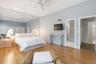 Wood-finish flooring with a ceiling fan, recessed lighting, and mirrored wall panels