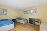Wood-finish flooring with multiple windows and light-colored walls