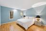 Wood-finish flooring, recessed ceiling lighting, light blue wall finishes, and two vertical windows