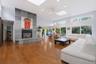 Vaulted ceilings, wood-finish flooring, stone-clad fireplace with hearth, multiple skylights, and expansive sliding glass doors