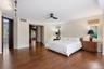 Spacious room with wood-finish flooring, two windows, and a ceiling fan
