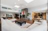 Spacious living area featuring high ceilings, wood-finish flooring, and multiple skylights