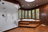 Wood-finish flooring, built-in soaking tub, bay windows, glass-enclosed shower with marble-finish tiling, and a skylight