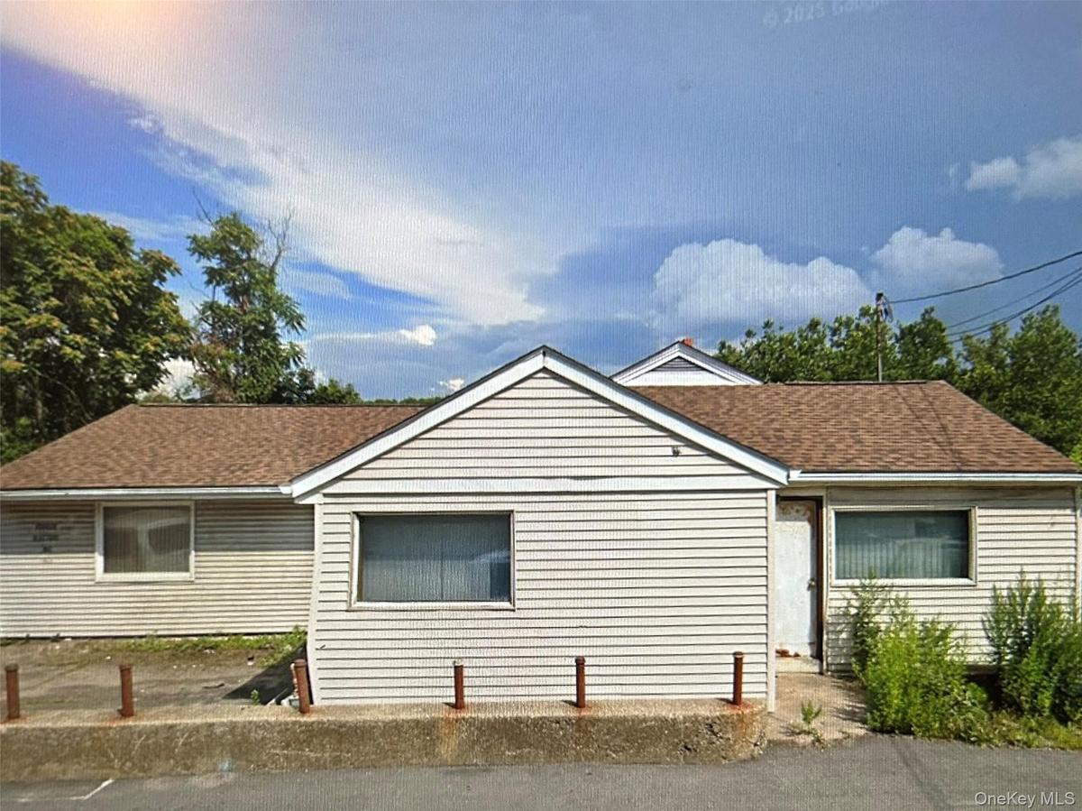 View of side of property featuring a shingled roof