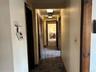 Corridor featuring dark carpet and baseboards