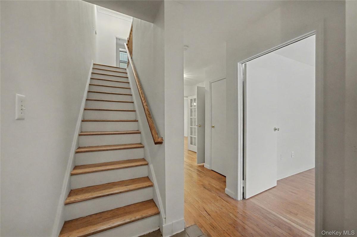 Staircase with wood finished floors and baseboards