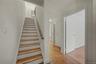 Staircase with wood finished floors and baseboards