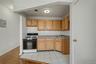 Kitchen with white range with gas cooktop, decorative backsplash, light countertops, electric panel, and light tile patterned floors
