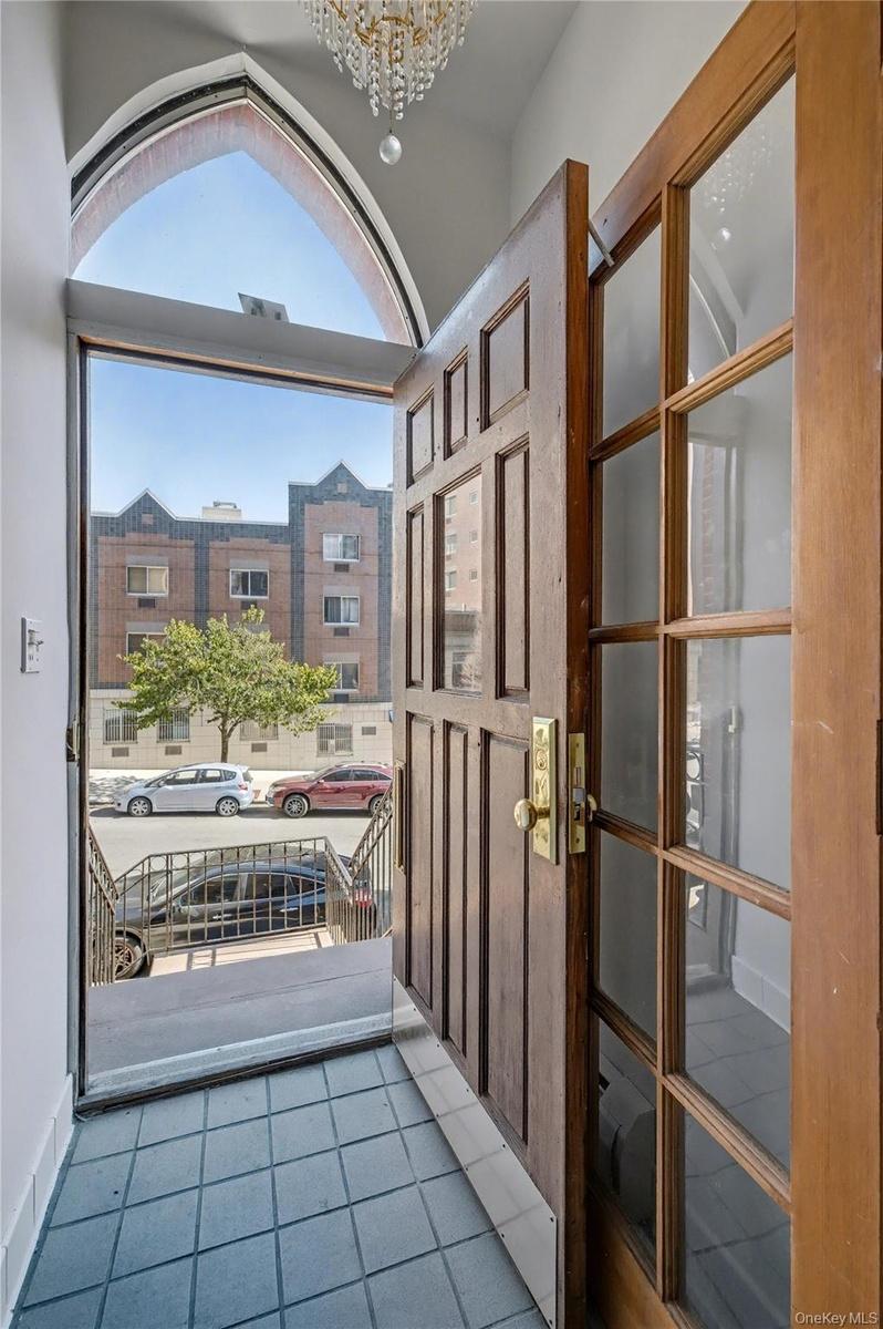 Doorway to outside featuring tile patterned floors and a chandelier