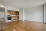 Kitchen featuring gas range oven, light wood-style flooring, tasteful backsplash, brown cabinets, and a baseboard radiator