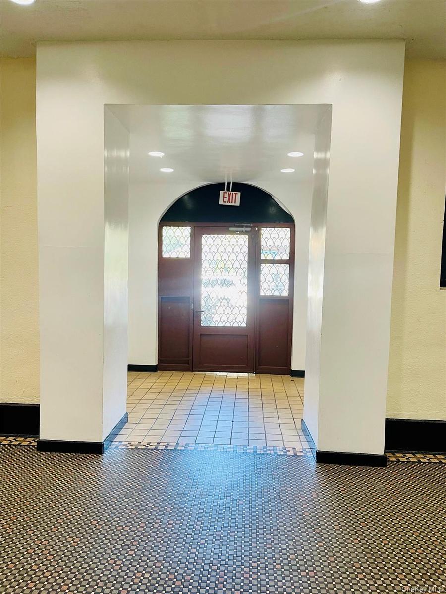 Entrance foyer with light tile patterned floors, baseboards, arched walkways, and recessed lighting