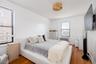 Bedroom featuring baseboards, light wood finished floors, and radiator heating unit