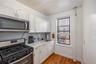 Kitchen featuring tasteful backsplash, light wood-type flooring, a sink, white cabinets, and stainless steel appliances