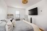 Bedroom featuring radiator, baseboards, and wood finished floors