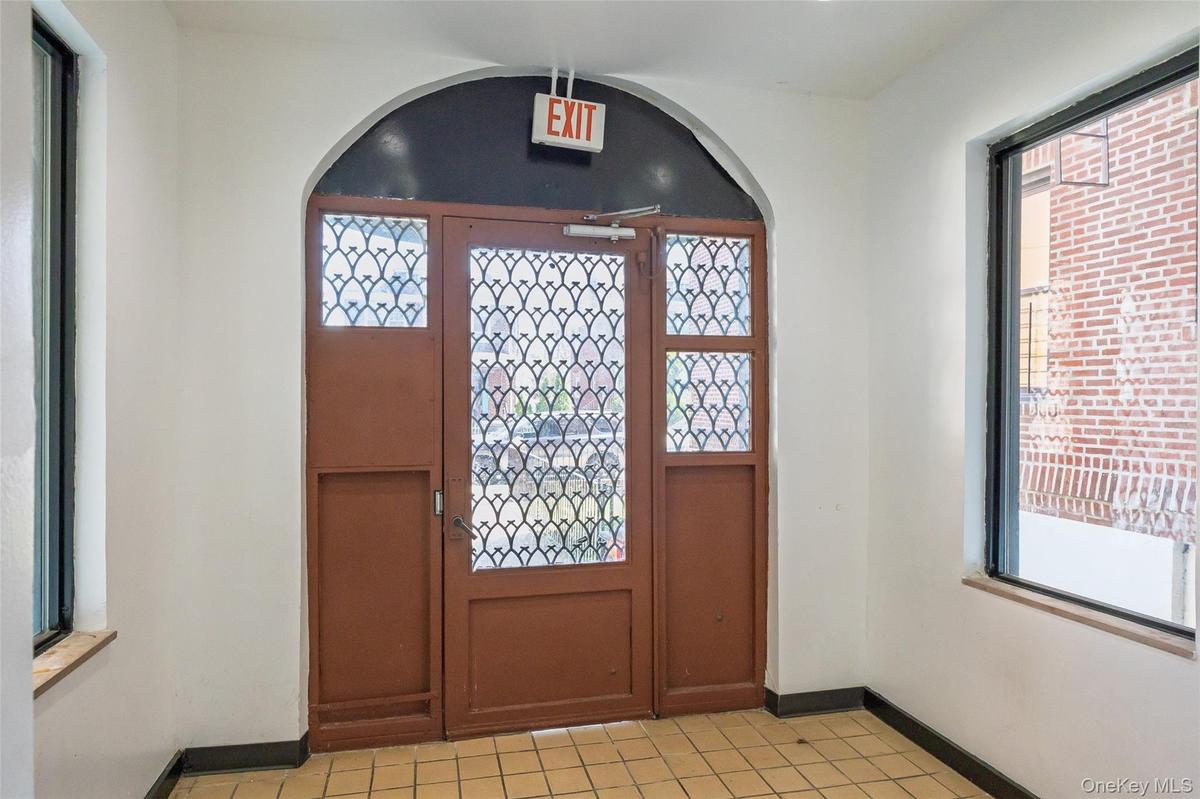 Entrance foyer featuring light tile patterned floors, arched walkways, baseboards, and a wealth of natural light