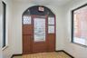 Entrance foyer featuring light tile patterned floors, arched walkways, baseboards, and a wealth of natural light