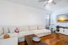 Living area with wood-type flooring, ceiling fan, baseboards, and radiator