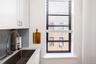 Interior details with a sink, light countertops, tasteful backsplash, and white cabinetry